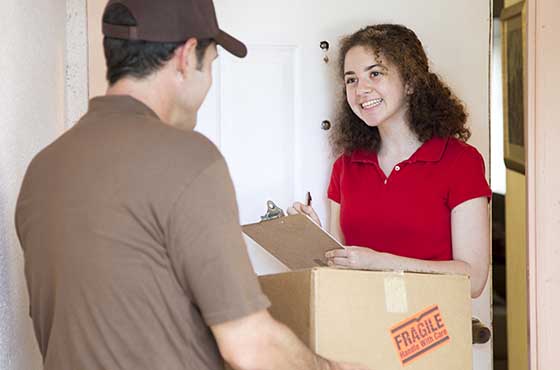 woman in red signing for a delivery